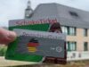 Zwei Karten "Schoko Ticket" und "Deutschland Ticket" mit eine Stadt im Hintergrund