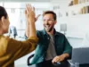 Zwei Personen in einer Büro-Umgebung schlagen ein