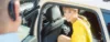 Weibliche Person in gelbem Kleid steigt aus einem Taxi aus