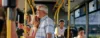 Eine Gruppe von Menschen fährt mit dem Bus, im Vordergrund ein Großvater mit seiner Enkelin