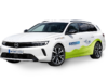 Es ist ein weißer Opel Astra zu sehen mit Branding von Stadtmobil CarSharing, Seitenansicht mit grüner Grafik und SR Carsharing Beschriftung. Es handelt sich um einen Benziner.